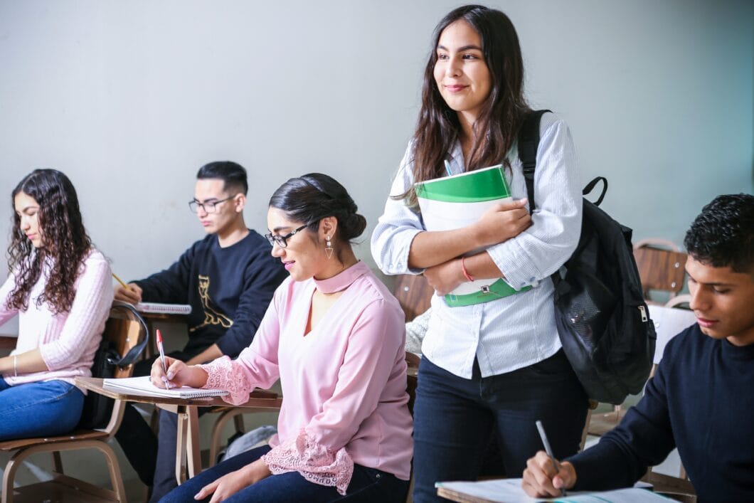 A young women standing confidently in a class to answer question